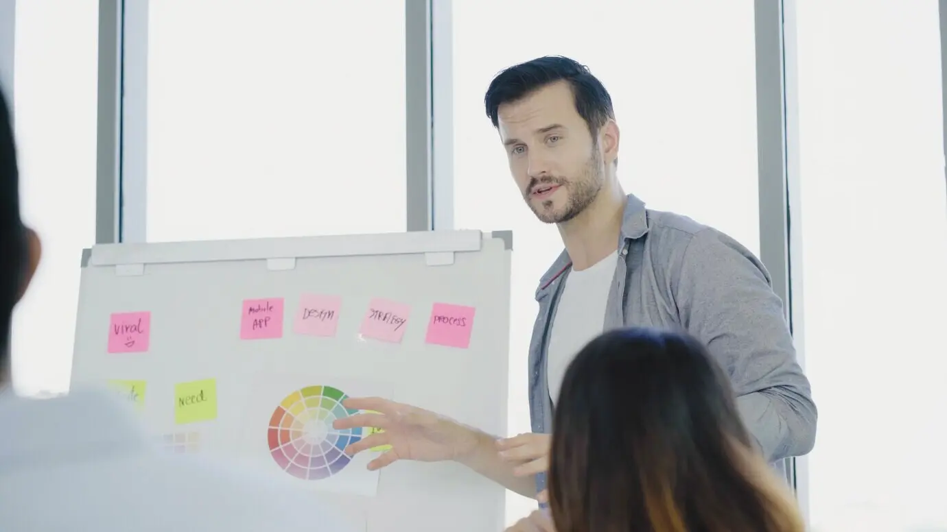 Успешный, красивый, умный азиатский креативный бизнесмен представляет креативную работу своему коллеге.