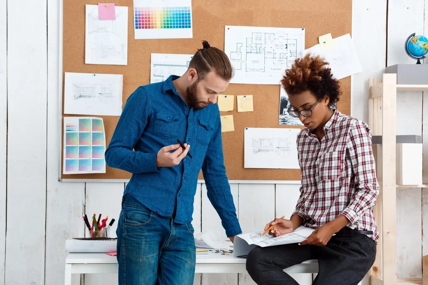 Коллеги улыбаются, разговаривают, обсуждают рисунки и новые идеи.